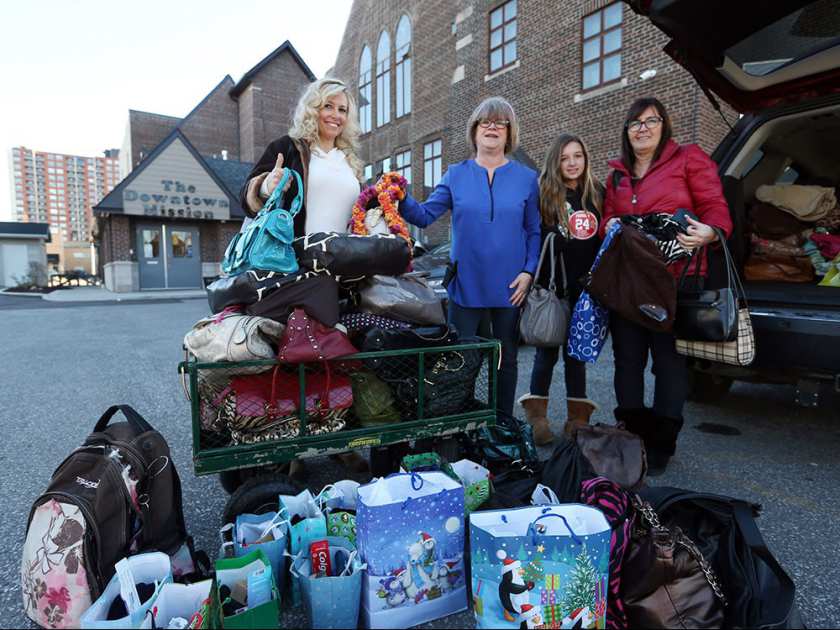 From left, Charmaine Gillis owner of Ocean Bottom Soap company, Mary-Jo Kovaks from the Downtown Mission, Veda Trepanier and Nurse Kim display more than 100 purses and man bags donated to the Downtown Mission on Dec. 24, 2015. Photo credit: Jason Kryk / Windsor Star